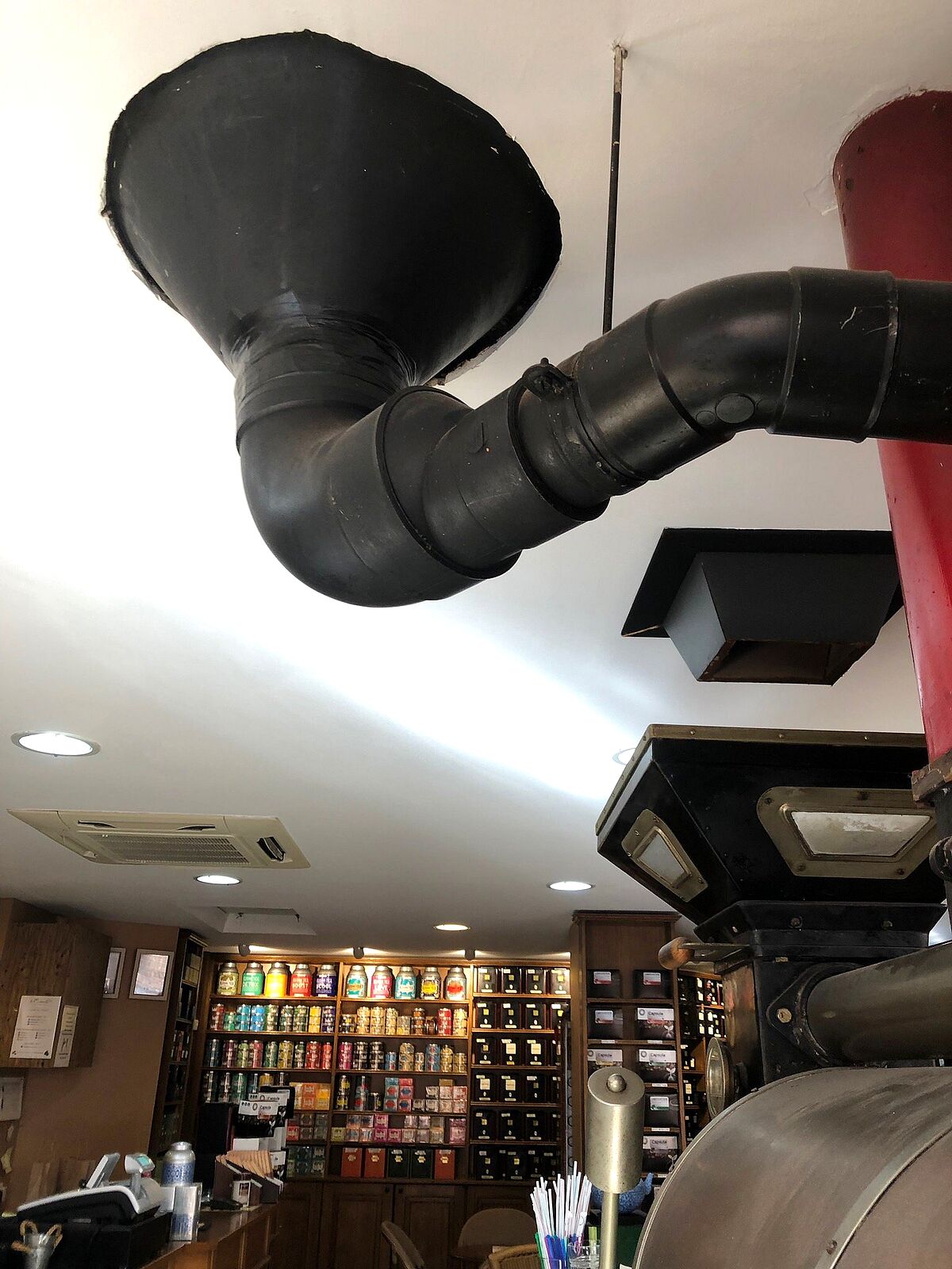 Le conduit noir du torréfacteur traversant le plafond de la boutique
