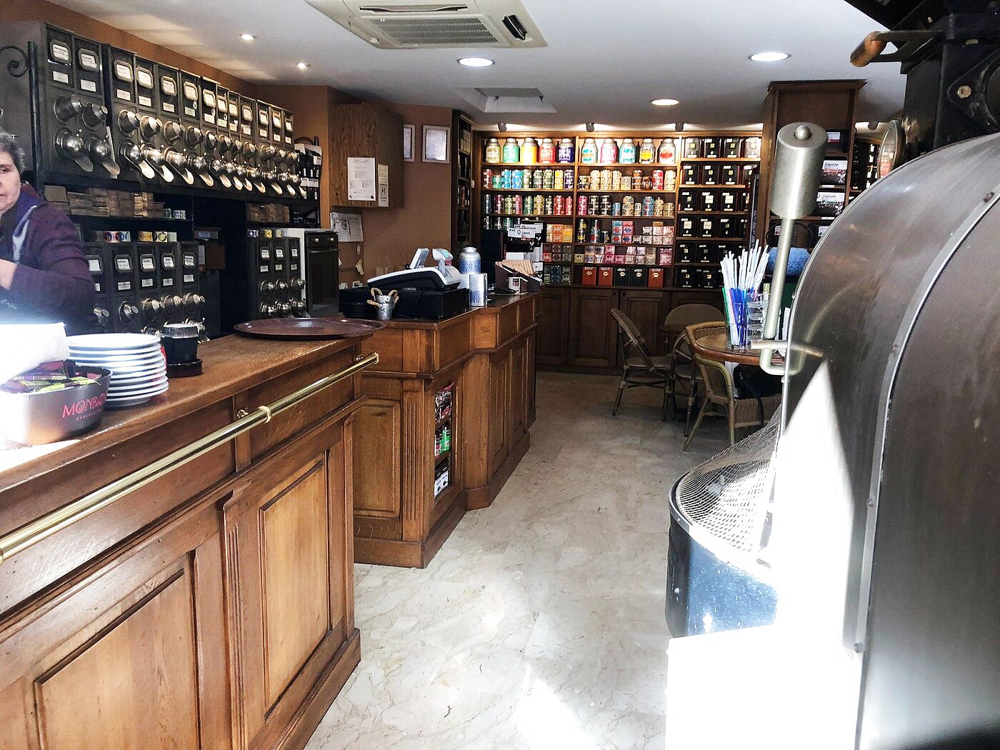 Le tambour refroidisseur du torréfacteur au premier plan, face au comptoir et au mur de thés