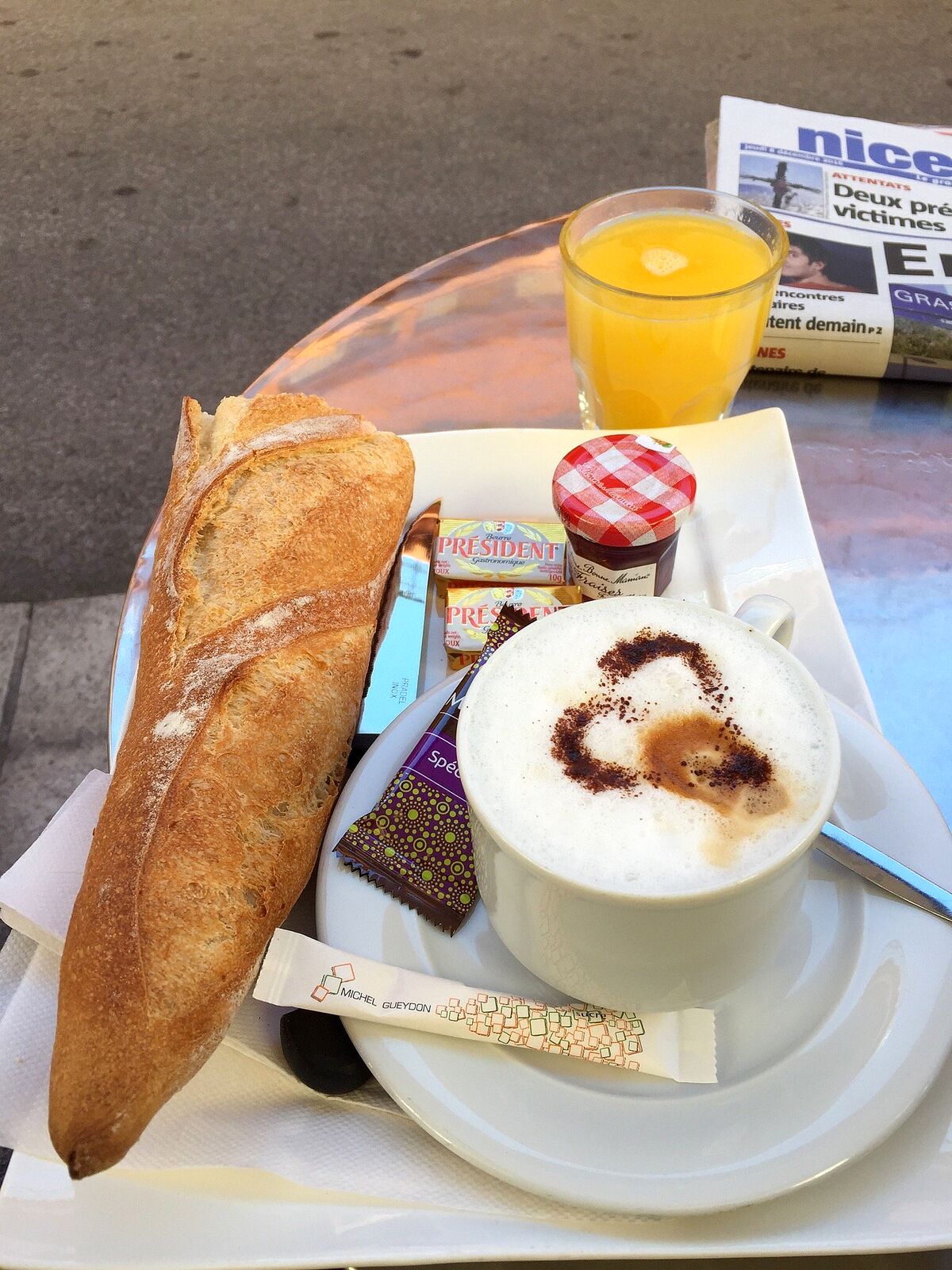 Petit-déjeuner en terrasse : demi-baguette, cappuccino, orange pressée