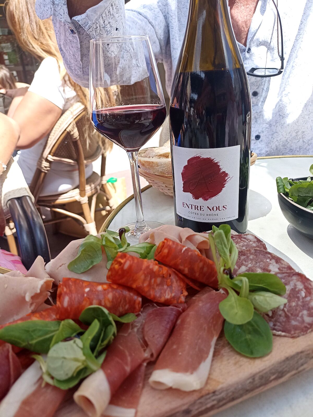 Planche de charcuteries et verre de vin rouge en terrasse
